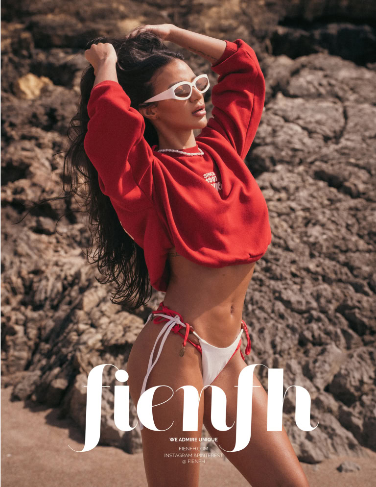 Magazine editorial page showing a woman in a red top leaning against coastal rocks